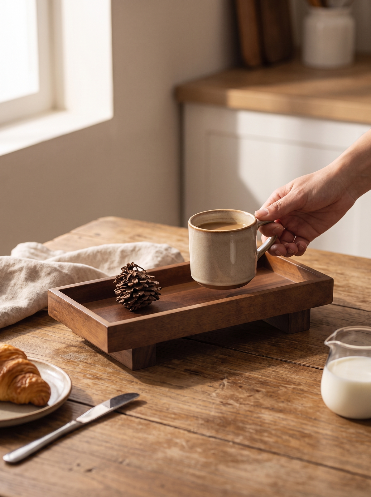 Cup sliding off the low lip of a wooden tea tray